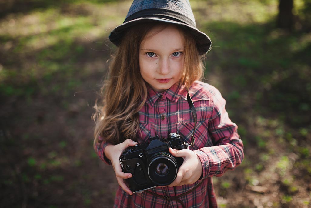 Girl in the woods with a camera